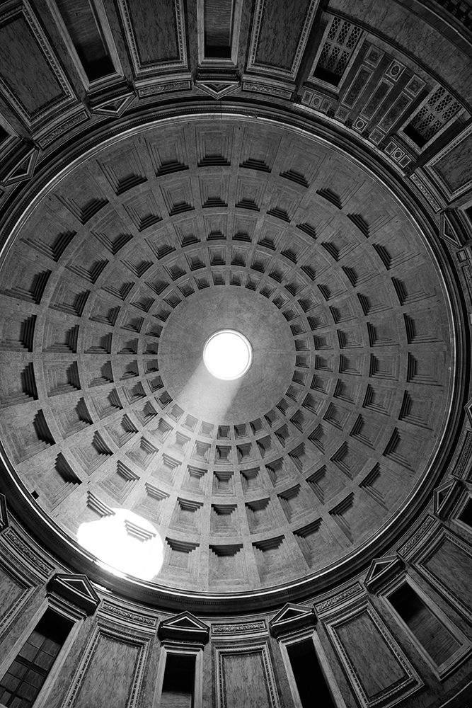 The sun illuminates the inside of the ceiling through the hole at the top of the Pantheon in Rome, Italy